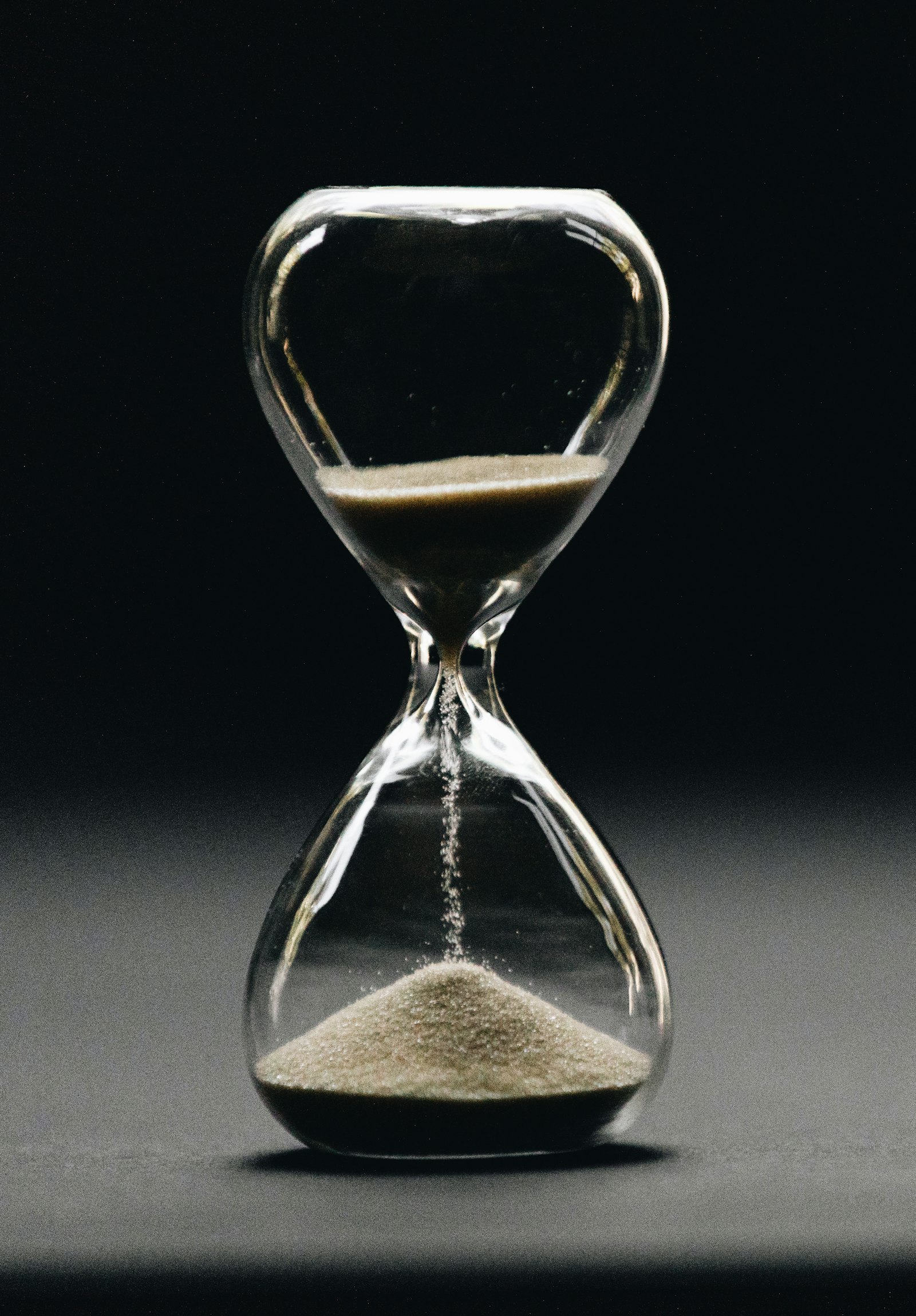 Reloj de arena de cristal con la arena cayendo