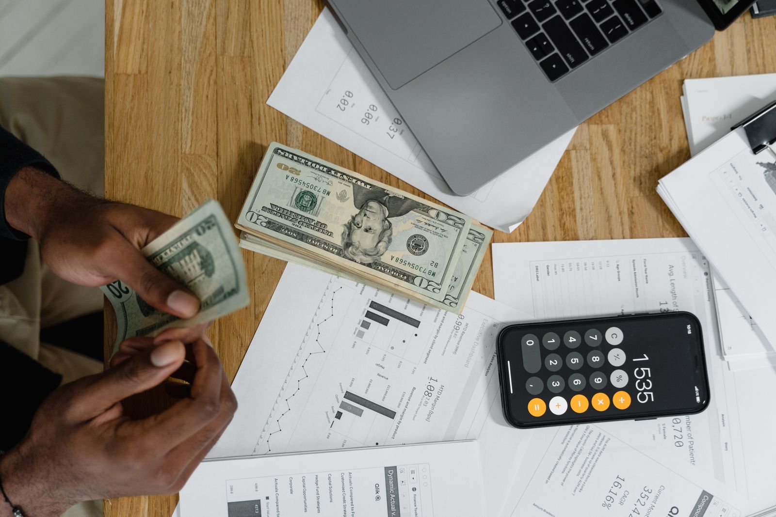 Manos contando billetes junto a una calculadora para estimar el coste real de un préstamo personal